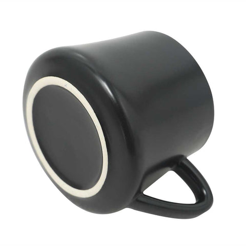 Black porcelain coffee mug with handle displayed upside down on a white background