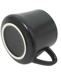 Black porcelain coffee mug with handle displayed upside down on a white background